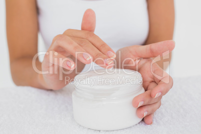 Mid section of woman applying cream