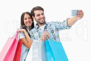 Attractive young couple with shopping bags taking a selfie