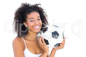 Pretty girl holding football and smiling at camera