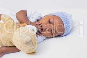 Adorable baby boy sleeping peacefully with teddy