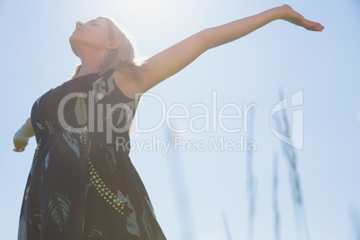 Pretty blonde in sundress standing with arms out