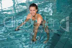 Fit brunette using underwater exercise bike