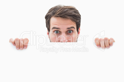 Attractive young man smiling and holding poster