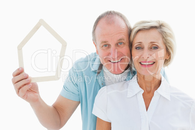 Happy older couple holding house shape Happy older couple holding house shape