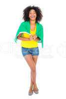 Pretty girl in yellow tshirt and brazilian flag smiling at camer