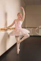 Beautiful ballerina standing en pointe holding barre