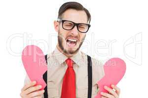 Geeky hipster crying and holding broken heart card