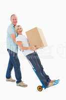 Fun older couple holding moving boxes