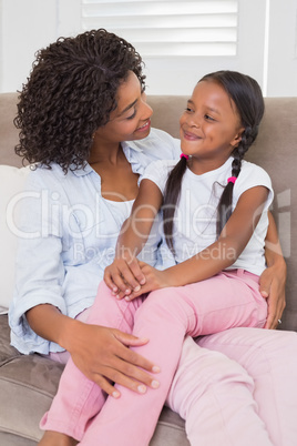 Pretty mother sitting on the couch with her daughter