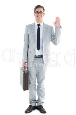Handsome businessman waving at camera