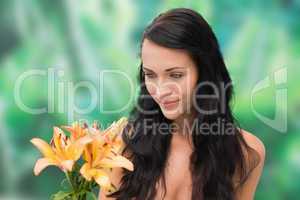 Beautiful nude brunette smiling at bunch of lilies