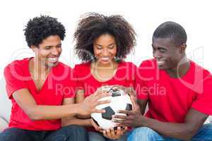 Football fans in red holding ball together