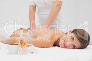 Attractive young woman receiving back massage at spa center