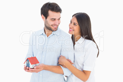 Attractive young couple holding a model house