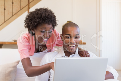 Cute couple relaxing on couch with laptop