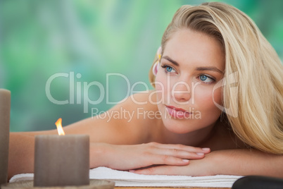 Peaceful blonde lying on towel with candle