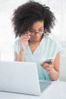 Happy businesswoman working on laptop sending a text