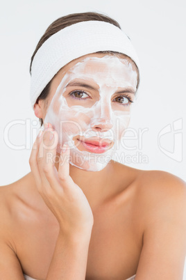 Attractive having white cream on her face at spa center