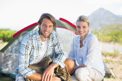 Attractive hiking couple smiling at camera outside their tent
