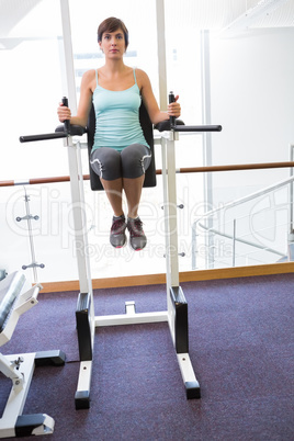 Fit brunette supporting her weight on bars