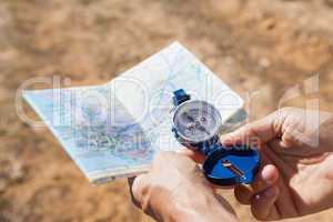 Hiker holding his compass and map in the countryside