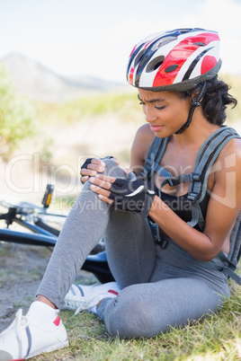 Fit woman holding her injured knee after bike crash