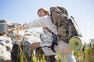 Handsome hiker hiking through rough terrain