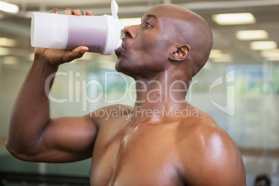 Sporty man drinking protein in gym