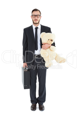 Geeky businessman holding briefcase and teddy