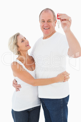 Mature couple smiling at camera with new house key