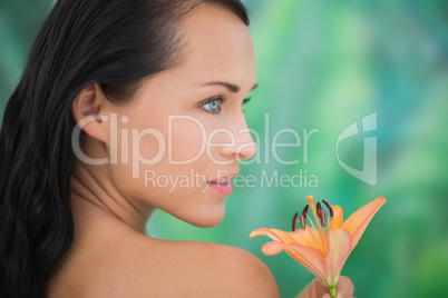 Beautiful nude brunette smelling lily