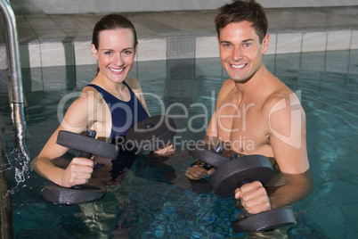 Happy couple working out with foam dumbbells