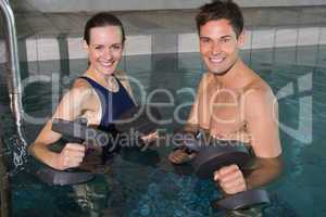 Happy couple working out with foam dumbbells