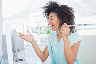 Casual businesswoman laughing at her desk