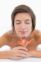 Close up of a beautiful young woman smelling flower