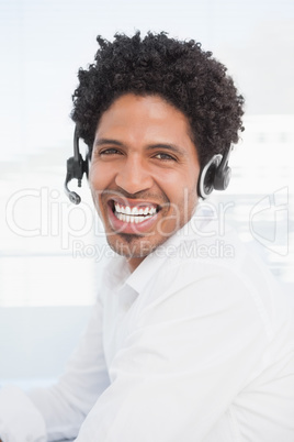 Happy businessman working at his desk wearing headset