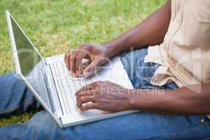 Man relaxing in his garden using laptop