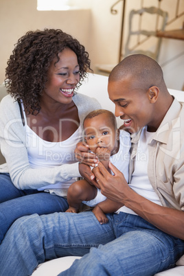 Happy parents spending time with baby on the couch