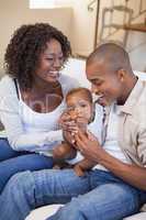 Happy parents spending time with baby on the couch