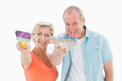 Happy older couple holding paintbrushes