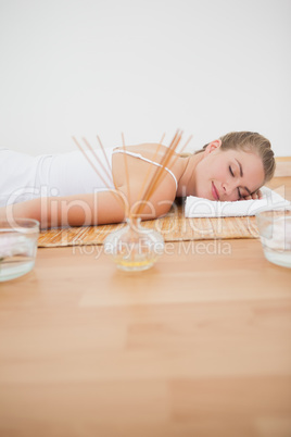 Beautiful blonde relaxing on bamboo mat