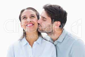 Handsome man kissing girlfriend on cheek