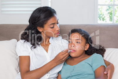 Concerned mother taking her daughters temperature