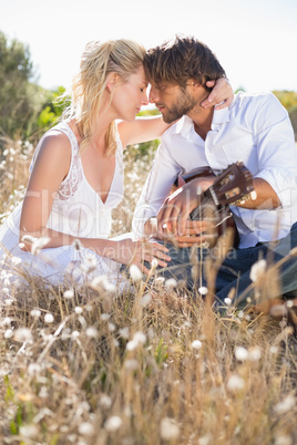 Handsome man serenading his girlfriend with guitar