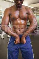 Muscular man flexing muscles in gym