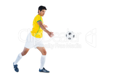 Football player in yellow kicking ball