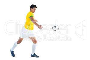 Football player in yellow kicking ball