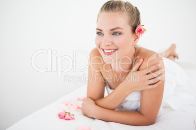 Pretty blonde lying on massage table with petals