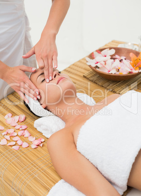 Peaceful brunette enjoying a face massage