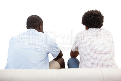 Two sports fans sitting on the couch